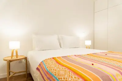 a bedroom with a bed with two lamps on a side table at Apartamentos Fernão de Ornelas by Heart of Funchal in Funchal