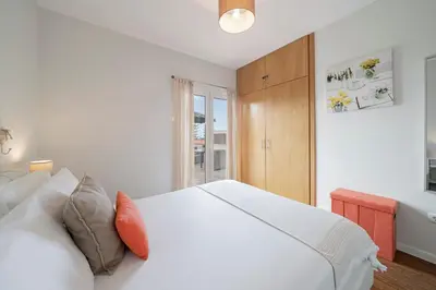 a white bedroom with a white bed and a window at Terrace Vila by An Island Apart in Caniço