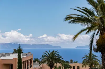 a view of the water and buildings and palm trees at Terrace Vila by An Island Apart in Caniço