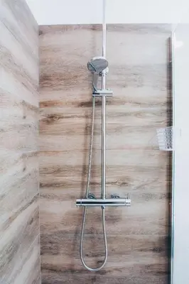 a shower in a bathroom with a wooden wall at Dorisol Vista Formosa by rentallido in Funchal