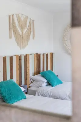 two beds with green pillows in a room at Vida Boa Lodge in Lagos