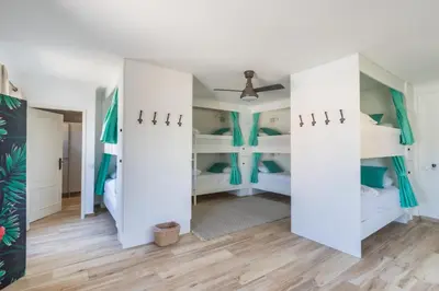 a room with white bunk beds and a ceiling at Vida Boa Lodge in Lagos