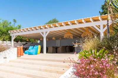 a white pergola with stairs in a garden at Vida Boa Lodge in Lagos