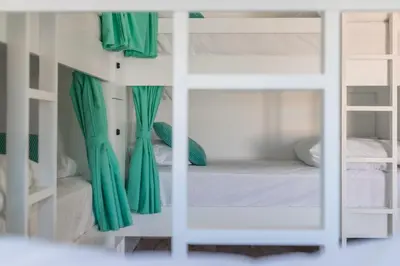 a room with two bunk beds with green curtains at Vida Boa Lodge in Lagos