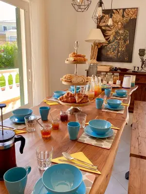 a wooden table with blue bowls and plates on it at Vida Boa Lodge in Lagos
