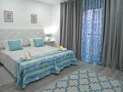 a bedroom with a large bed with blue curtains at Town Apartment in Funchal