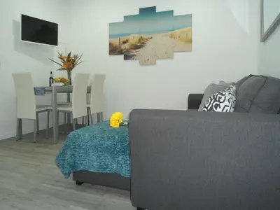 a living room with a couch and a table with chairs at Town Apartment in Funchal