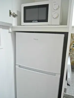 a microwave on top of a refrigerator in a kitchen at Town Apartment in Funchal