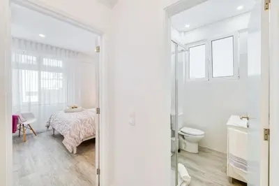 a white bedroom with a bed and a toilet at Os Fragosinhos by Amazing Madeira in Funchal