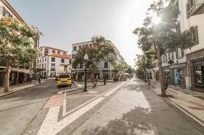 an empty city street with a yellow van driving down the street at Os Fragosinhos by Amazing Madeira in Funchal