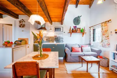 a kitchen and living room with a table and a couch at Casa Da Muda in Ponta do Pargo
