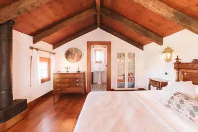 a bedroom with a bed and a desk and a window at Casa Da Muda in Ponta do Pargo