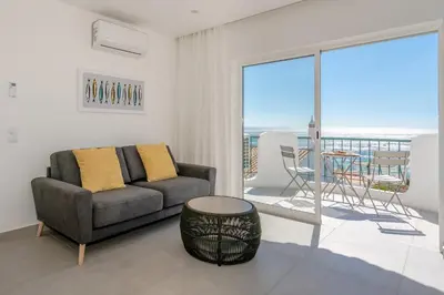 a living room with a couch and a table at Waterside Village - Sea View Apartment in Alagoas