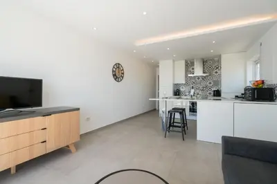 a kitchen with white cabinets and a flat screen tv at Waterside Village - Sea View Apartment in Alagoas