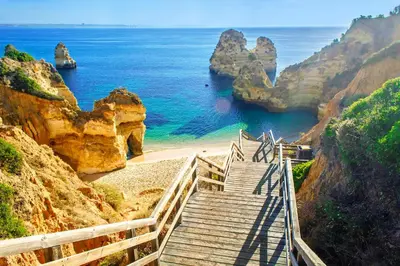 a staircase leading to a beach near the ocean at Waterside Village - Sea View Apartment in Alagoas