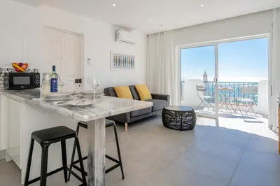 a kitchen and living room with a table and a couch at Waterside Village - Sea View Apartment in Alagoas