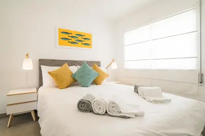 a bedroom with a white bed with towels on it at Waterside Village - Sea View Apartment in Alagoas