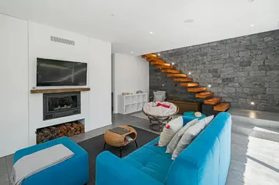 a living room with a blue couch and a fireplace at Casa da Maloeira by An Island Apart in Fajã da Ovelha