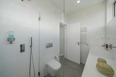 a white bathroom with a toilet and a shower at Casa da Maloeira by An Island Apart in Fajã da Ovelha