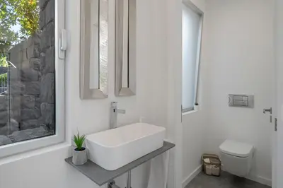 a white bathroom with a sink and a toilet at Casa da Maloeira by An Island Apart in Fajã da Ovelha