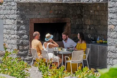 a group of people sitting at a table at Casa da Maloeira by An Island Apart in Fajã da Ovelha