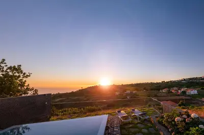 a view of the sunset from the balcony of a house at Casa da Maloeira by An Island Apart in Fajã da Ovelha