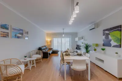 a living room with a table and chairs and a dining room at Apartamento 7 Mares com 2 Quartos in Sagres