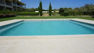 a swimming pool with blue water in a yard at Apartamento 7 Mares com 2 Quartos in Sagres