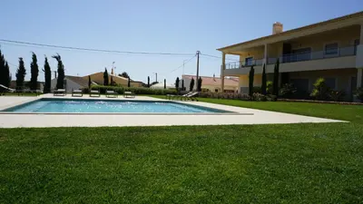 a swimming pool in a yard next to a building at Apartamento 7 Mares com Suite in Sagres