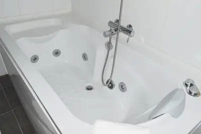 a white bath tub with a shower in a bathroom at Design Gardens, a Home in Madeira in Funchal