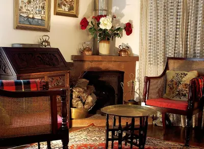 a living room with a fireplace and a table and chairs at Vila Joaninha in Santo da Serra