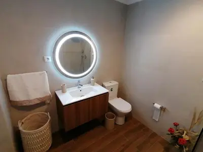 a bathroom with a sink and a toilet and a mirror at Vila Joaninha in Santo da Serra