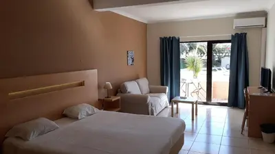a hotel room with a bed and a chair and a window at Vilamar in Luz