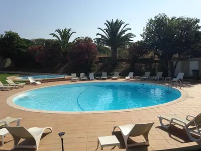 a large swimming pool with chairs and chairs in a resort at Vilamar in Luz