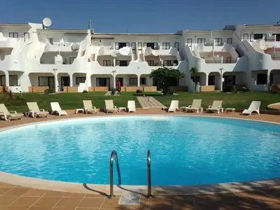 a swimming pool in front of a large building at Vilamar in Luz
