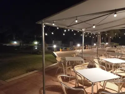 a group of tables and chairs under a tent at night at Vilamar in Luz