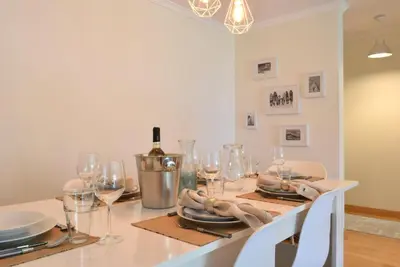 a dining room with a table with wine glasses at Machico Beach, a Home in Madeira in Machico