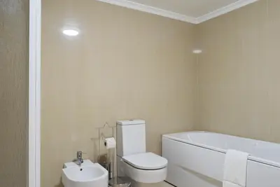 a bathroom with a white toilet and a sink at Machico Beach, a Home in Madeira in Machico