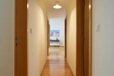 a hallway of a house with wooden floors and white walls at Machico Beach, a Home in Madeira in Machico