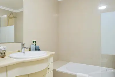 a white bathroom with a sink and a shower at Machico Beach, a Home in Madeira in Machico