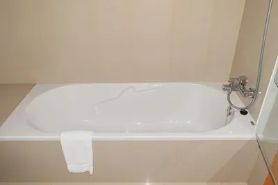 a white bath tub in a bathroom with a towel at Machico Beach, a Home in Madeira in Machico