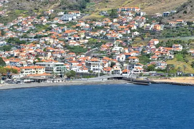 a town with a bridge over a body of water at Machico Beach, a Home in Madeira in Machico