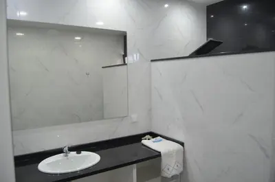a white bathroom with a sink and a mirror at Descobrir Madeira in Gaula