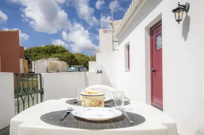 a table with a plate of food on a balcony at C14 - Casa da Luz in Luz