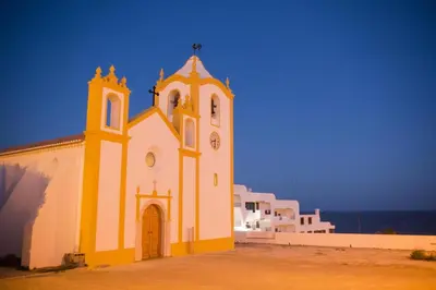 a yellow and white church with a clock tower at C14 - Casa da Luz in Luz