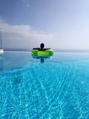 a man in the water on a raft in the water at Luxo & Conforto in Calheta