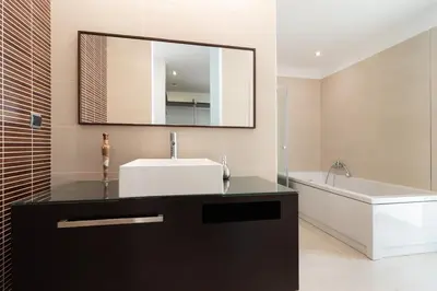 a bathroom with a sink and a tub and a mirror at Luxo & Conforto in Calheta
