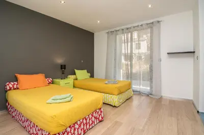 two beds in a room with a window at Luxo & Conforto in Calheta