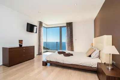 a bedroom with a bed and a large window at Luxo & Conforto in Calheta