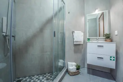 a bathroom with a glass shower and a sink at Trendy Apartments in Funchal